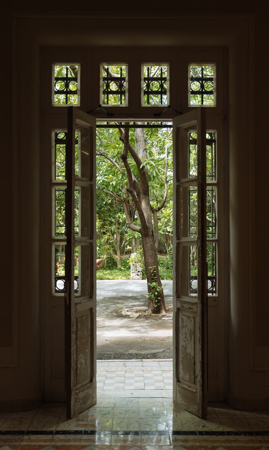 Puerta de doble hoja abierta hacia el jardín en una casa del Centro de Mérida